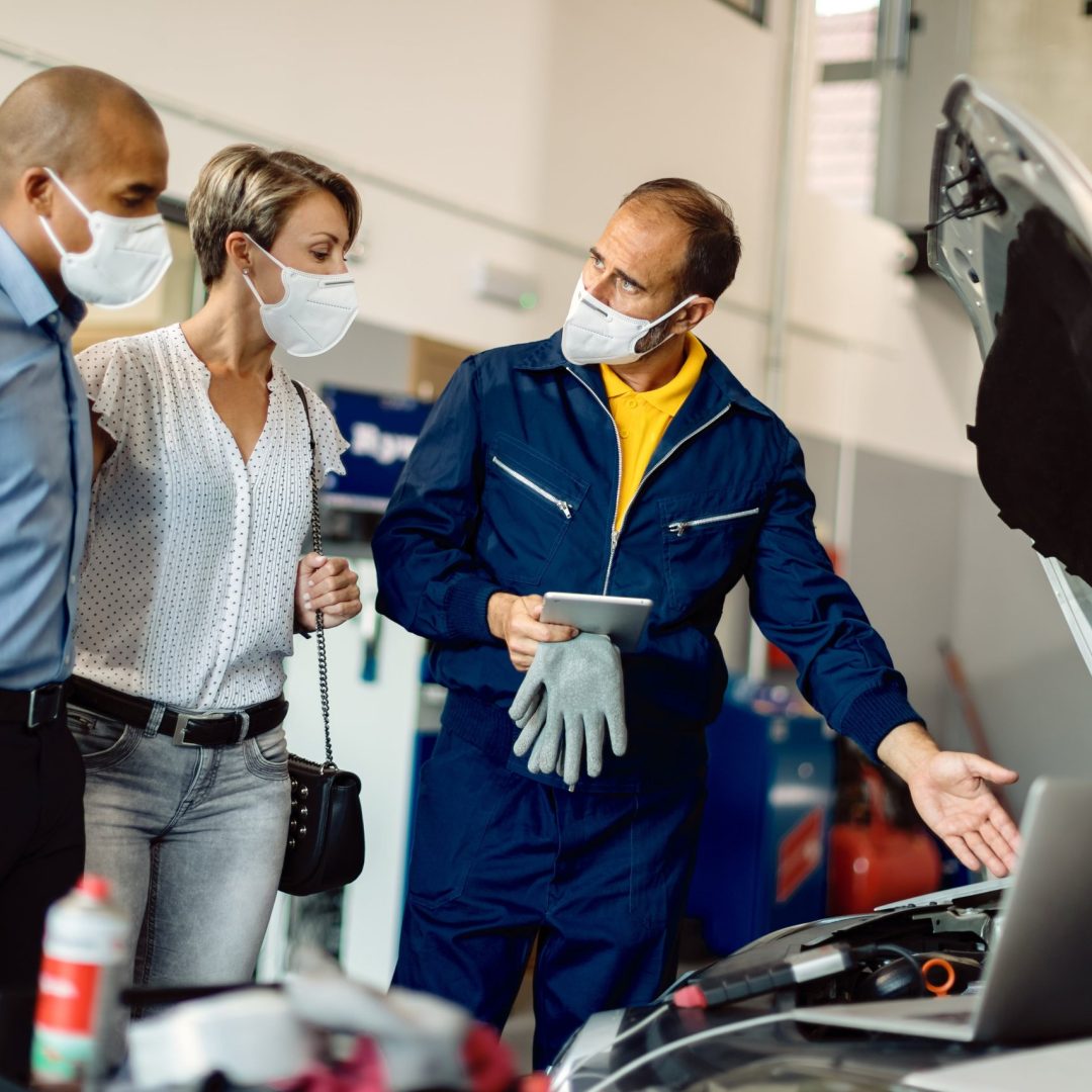 auto-mechanic-his-customers-talking-while-examining-vehicle-breakdown-workshop-during-coronavirus-pandemic-min